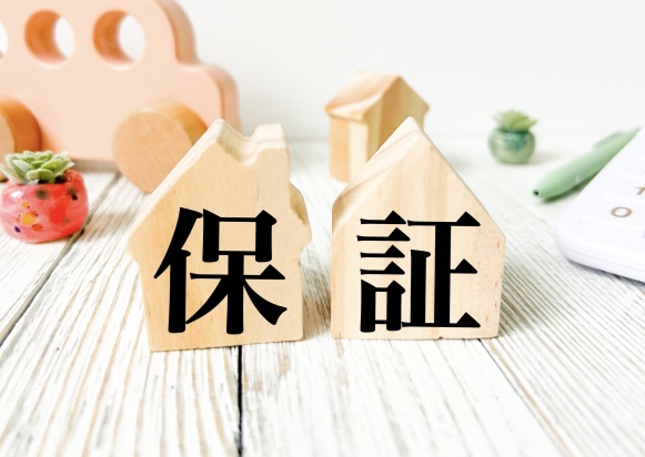 保証と書かれた家型の木製オブジェ